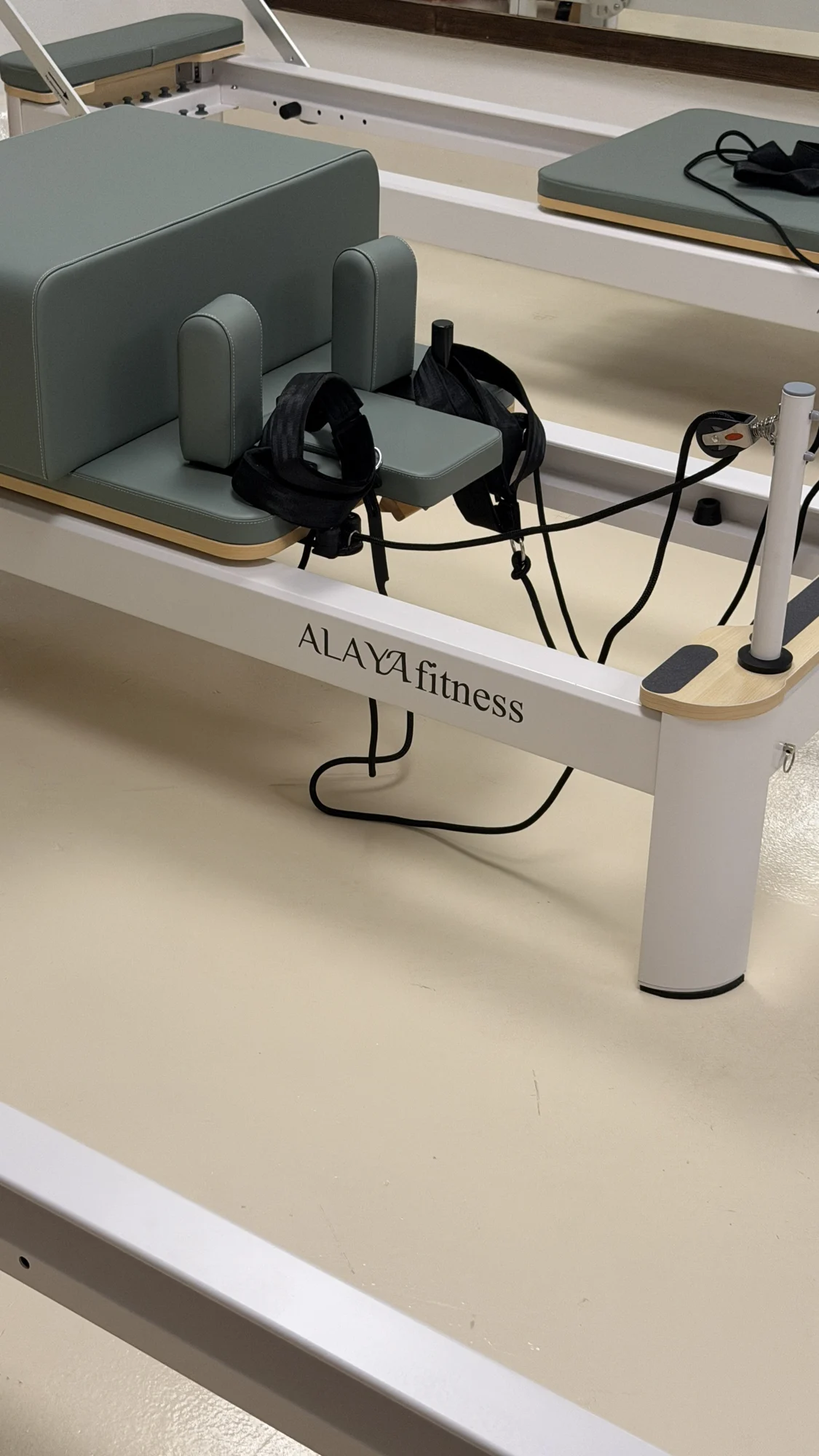 Close view of an Alaya reformer carriage, ropes and white frame at VERDE Studio