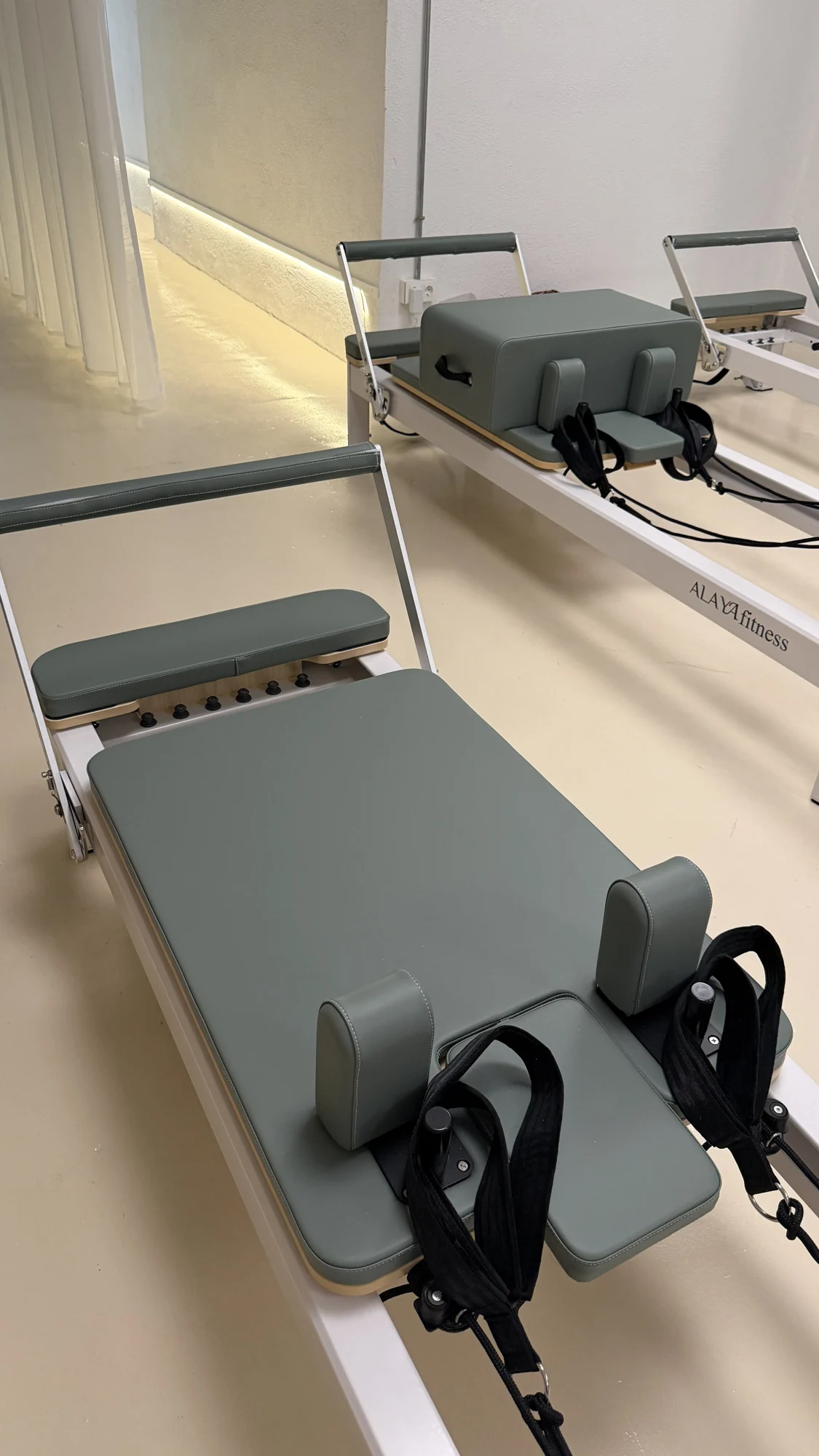 Custom Alaya reformers with green upholstery in the sunlit VERDE Studio in Barcelona